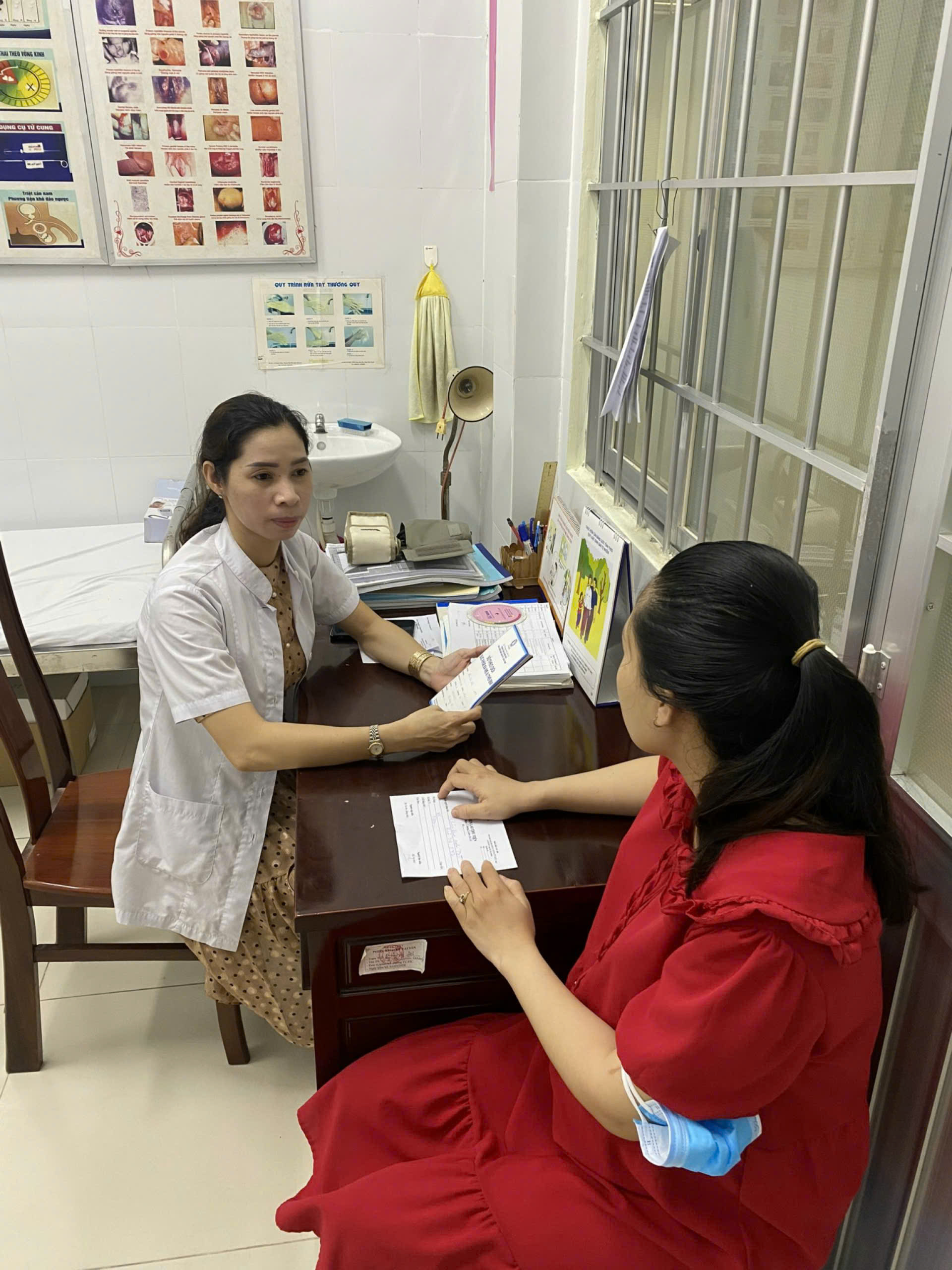 Hình 01 Nhân viên Trạm Y tế tư vấn sàng lọc trước sinh và sơ sinh cho thai phụ - Ảnh: TRẦN THỊ XÍU